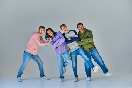 Photo for Cheerful friends in casual outfits having great time posing on grey backdrop, cultural diversity - Royalty Free Image