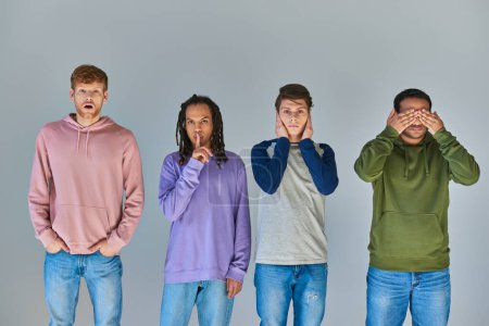 Foto de Cuatro amigos con atuendo casual brillante de pie y gestos sobre fondo gris, diversidad cultural - Imagen libre de derechos