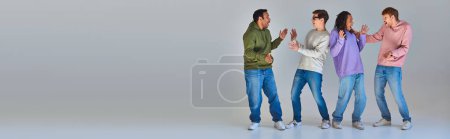 Photo for Four cheerful astonished men in street wear looking at each other, cultural diversity, banner - Royalty Free Image