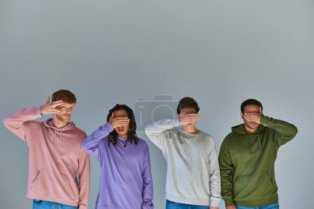 Photo for Multicultural friends in urban wear closing eyes with palms one peeking looking at camera, diversity - Royalty Free Image