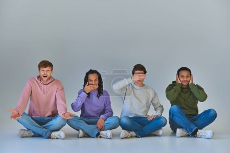 Foto de Cuatro jóvenes sentados con las piernas cruzadas y haciendo gestos, como cuatro sabios monos concepto, diversidad - Imagen libre de derechos