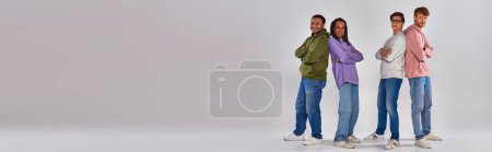 Téléchargez les photos : Hommes multiculturels debout dos à dos et souriant à la caméra sur fond gris, diversité, bannière - en image libre de droit