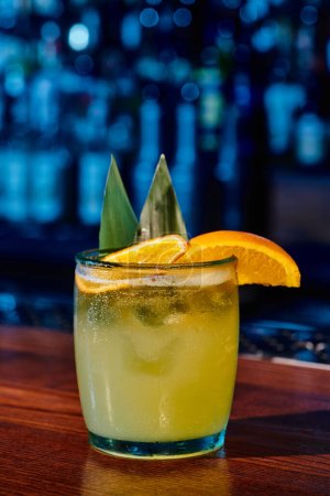 Glas altmodischer Cocktail mit Orangenscheibe mit Bar auf Hintergrund, Konzept