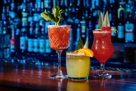 verres de trois cocktails rafraîchissants différents avec des décorations sur le comptoir du bar, concept
