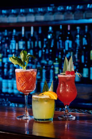 Téléchargez les photos : Trois cocktails sophistiqués avec des décorations fraîches sur le comptoir du bar, photo d'objet, concept - en image libre de droit