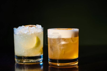 sophisticated whiskey sour and exotic caipirinha on black background, object photo, concept