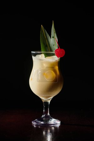 elegante Pina Colada mit Cocktailkirsche auf schwarzem Hintergrund, Objektfoto, Konzept