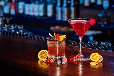Photo for Tropical negroni and cosmopolitan cocktails garnished with cocktail cherries, concept - Royalty Free Image