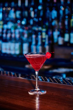 Téléchargez les photos : Élégant cocktail cosmopolite en verre de martini avec cerise sur comptoir, concept - en image libre de droit