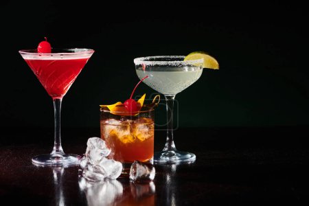 anspruchsvolle erfrischende Cocktails mit Garnierungen auf schwarzem Hintergrund, Konzept