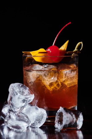 sophisticated elegant negroni cocktail with cherry and ice on black backdrop, concept