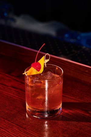 ice cold sophisticated glass of negroni decorated with cherry on bar counter, concept