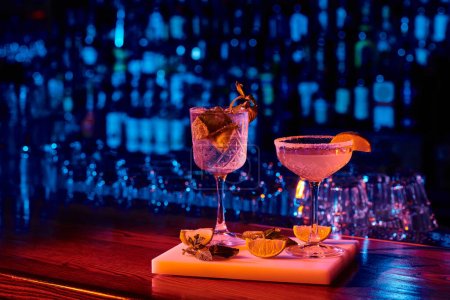 Photo pour Verre sophistiqué de délicieux cocktails avec garnitures sur comptoir de bar, concept - image libre de droit
