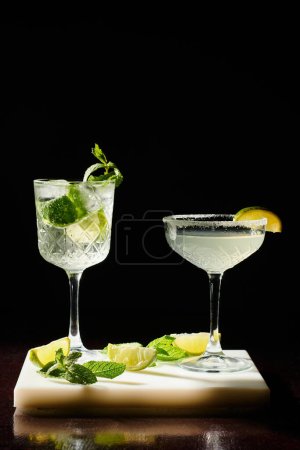 Téléchargez les photos : Margarita apaisante de soif et rhapsodie bohème avec de la chaux sur fond noir, concept - en image libre de droit