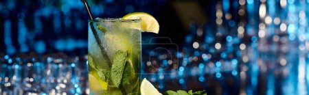 esthetic mojito cocktail with mint leaves and lime on bar backdrop, concept, banner