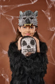 portrait of smiling girl in wolf mask and black attire hugging spooky toy, Halloween, close up Stickers #676677226