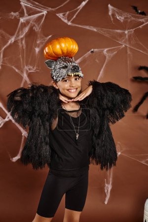 close up smiling preteen girl with pumpkin on her head and hands under chin, Halloween