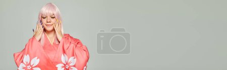 Téléchargez les photos : Femme cosplay heureux avec perruque blonde et manucure colorée posant en kimono rose sur gris, bannière - en image libre de droit