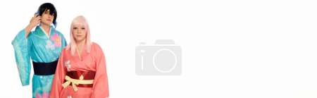 Téléchargez les photos : Jeune couple cosplay en kimonos colorés et perruques regardant la caméra sur blanc, bannière horizontale - en image libre de droit