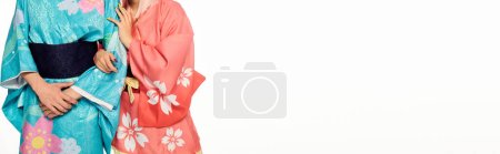 Téléchargez les photos : Vue recadrée de jeunes cosplayers portant des kimonos japonais colorés sur bannière blanche et horizontale - en image libre de droit