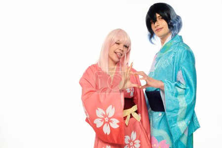 anime style woman sticking out tongue and showing heart sigh with extravagant man in kimono on white