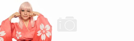 cosplay mujer en kimono rosa con los puños cerca de la cara y guiño a la cámara en blanco, bandera horizontal