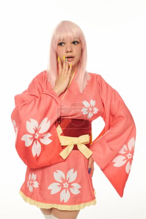 shocked anime style woman in pink with hand on hip touching face on white, cosplay character