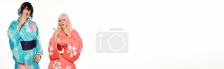 Photo for Surprised  cosplayers in bright kimonos and wigs touching faces on white, horizontal banner - Royalty Free Image