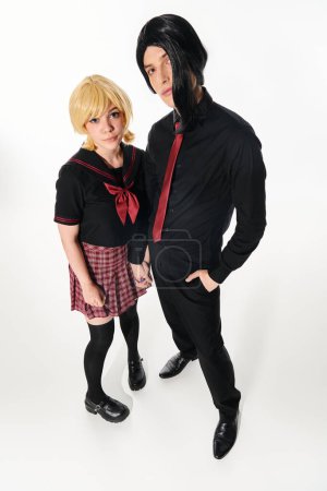 wide angle view of anime style students in wigs and dark uniform looking at camera on white
