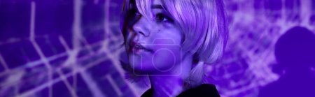 portrait of charming anime woman in blonde wig in blue neon light on abstract backdrop, banner