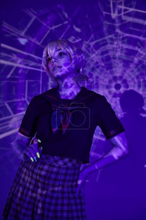 Photo for Young anime style woman in school uniform posing with hand on hip in blue abstract projection - Royalty Free Image