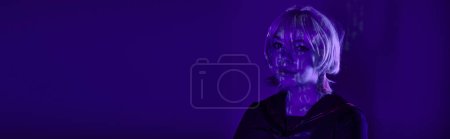 Photo for Portrait of female cosplayer in blonde wig with hieroglyphs projection in blue neon light, banner - Royalty Free Image