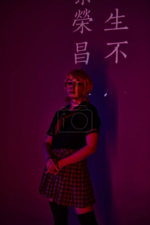 Anime-Frau in Perücke und Schuluniform in Neonlicht vor violettem Hintergrund mit Hieroglyphen-Projektion