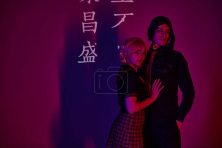 junge Anime-Studenten in Uniform in Neonlicht vor violettem Hintergrund mit Hieroglyphen-Projektion