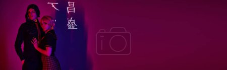 Photo for Cosplay students in uniform in neon light on purple backdrop with hieroglyphs projection, banner - Royalty Free Image