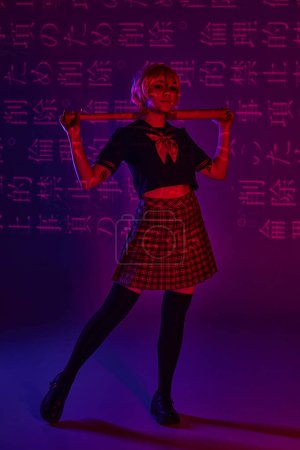 junge Anime-Frau in Schuluniform mit Baseballschläger auf neonviolettem Hintergrund mit Hieroglyphen