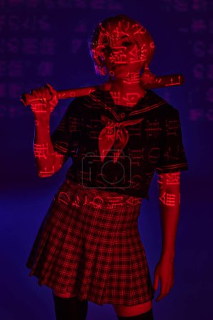 Photo for Young anime woman in school uniform with baseball bat in red neon light with hieroglyphs on blue - Royalty Free Image