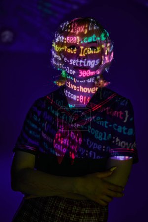 woman in students uniform in neon programming symbols projection on blue backdrop, cosplay concept