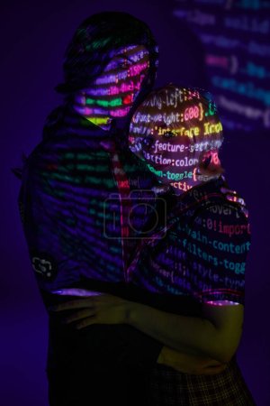 modern couple in colorful neon programming symbols projection on blue backdrop, cosplay concept