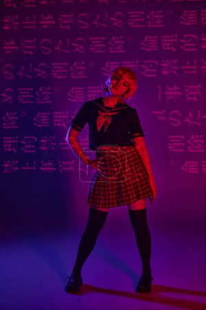 Anime mujer en uniforme escolar con la mano en la cadera en luz de neón sobre fondo púrpura con jeroglíficos