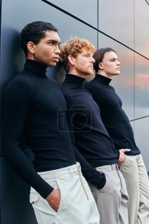 Téléchargez les photos : Beaux beaux hommes interracial posant côte à côte à côté du mur, de la mode et du style - en image libre de droit