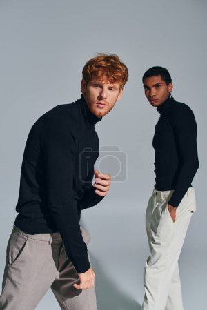 red haired bearded and african american men standing and looking at camera, fashion concept