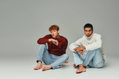 Téléchargez les photos : Multiculturel beaux modèles masculins dans des pulls chauds assis sur le sol en regardant la caméra, hommes puissance - en image libre de droit