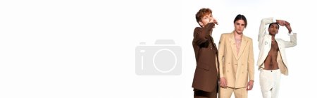 tempting multicultural men in stylish vibrant suits gesturing and looking at camera, banner