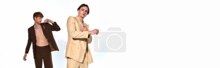 appealing young man in beige suit posing with other male model in unbuttoned suit, men power, banner