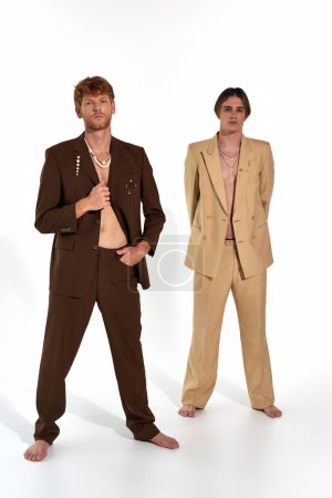 Foto de Tiro vertical de atractivos modelos masculinos en trajes elegantes de pie y mirando a la cámara, los hombres de energía - Imagen libre de derechos