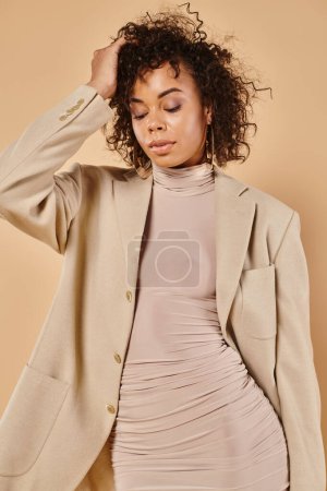 Photo for Fall fashion, curly african american woman posing in autumn dress and blazer on beige backdrop - Royalty Free Image