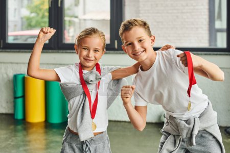 Photo for Happy preadolescent boy and girl having great time wearing golden medals and smiling at camera - Royalty Free Image