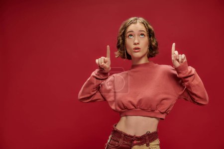 Jugendkultur, Gen-Z-Mädchen in abgeschnittenem Langarm zeigt mit den Fingern und blickt auf rot