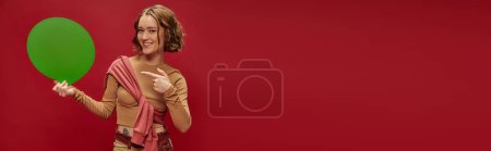 Téléchargez les photos : Femme heureuse en patchwork pantalon et pull sur manches longues pointant vers bulle de parole, bannière - en image libre de droit
